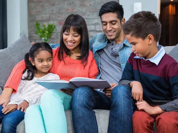 Familia leyendo junta en el sofá